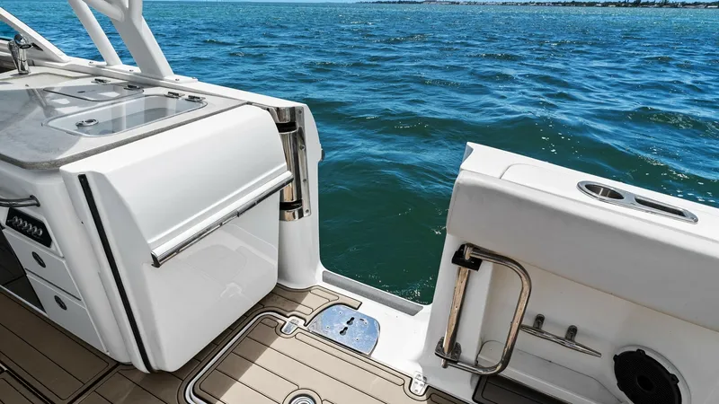 Slide: The Image of Cockpit Galley and Aft Access This image showcases the cockpit galley and aft access area of the 2019 Boston Whaler 320 Vantage. The galley features a sleek stainless steel sink and ample storage, perfect for onboard entertaining. The aft door provides easy access to the swim platform - 7469830