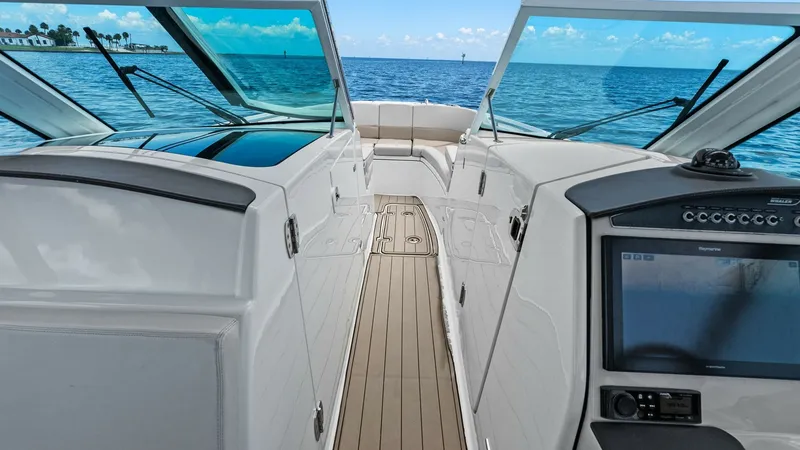 Slide: The Image of Walkthrough to Bow Seating Area This image showcases the sleek walkthrough leading to the bow seating area of the 2019 Boston Whaler 320 Vantage. The teak decking adds a touch of elegance while providing a durable, non-slip surface. The open windshield and panoramic views enhance the fe - 7469821