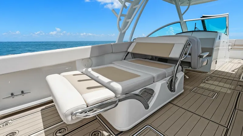 Slide: The Image of Convertible Cockpit Seating Area This image features the versatile cockpit seating area of the 2019 Boston Whaler 320 Vantage. The seating is designed for comfort and flexibility, with adjustable backrests and plush cushioning in a sleek, modern design. The teak flooring adds a touch of - 7469828