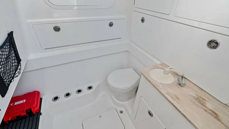 Slide: The Image of Compact Bathroom with Vanity This efficient bathroom on the 2025 Valhalla V-41 features a sleek design with a compact toilet and a practical vanity area. The white cabinetry provides ample storage, while the neutral countertop adds a touch of elegance. Thoughtful details, like the ov - 7517255
