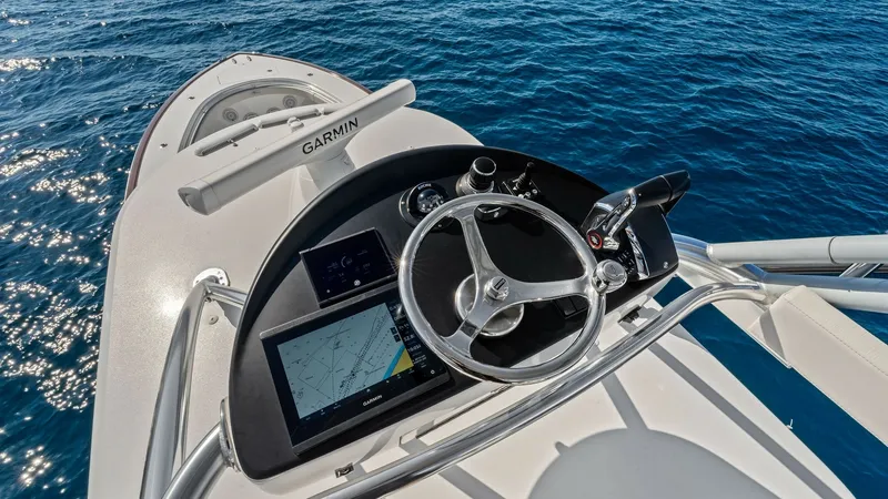 Slide: The Image of Flybridge Helm Station Experience state-of-the-art navigation from the flybridge helm of the 2025 Valhalla V-41. This area features a sleek steering wheel, integrated Garmin display, and advanced controls for seamless operation. The helm's elevated position offers commanding vi - 7517265