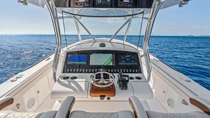 Slide: The Image of Helm Station with Advanced Electronics The helm station of the 2025 Valhalla V-41 features state-of-the-art electronics, including multiple multifunction displays for navigation and system monitoring. The ergonomic design is complemented by a luxurious leather-wrapped steering wheel and comfor - 7517252