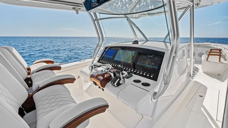 Slide: The Image of Helm Station with Advanced Electronics The helm station of the 2025 Valhalla V-41 showcases state-of-the-art navigation technology with large, integrated display screens and precision controls. The elegant design features plush, quilted seating with rich wood accents, offering comfort and styl - 7517251