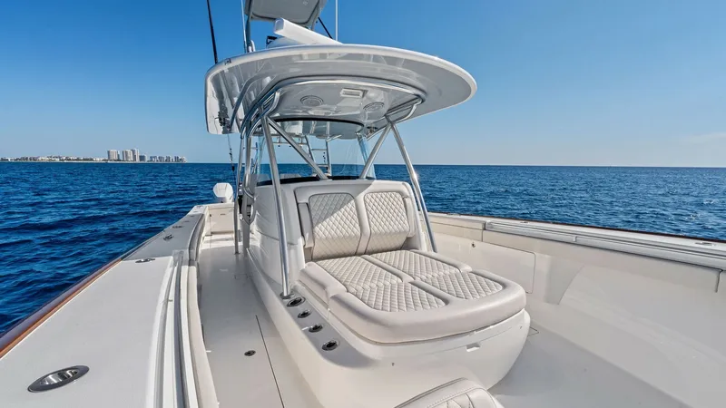 Slide: The Image of Center Console Seating Area This image showcases the luxurious center console seating area of the 2025 Valhalla V-41. The upholstered seating features elegant diamond stitching, providing both style and comfort. Overhead, a sleek T-top offers shade, making this space perfect for rel - 7517250