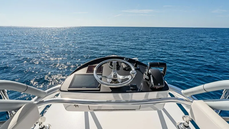 Slide: The Image of Flybridge Helm Station with Ocean View Experience unparalleled control and visibility from the flybridge helm station of the 2025 Valhalla V-41. The sleek, modern console features advanced navigation equipment and a polished steering wheel, ensuring a seamless piloting experience. Surrounded b - 7517264