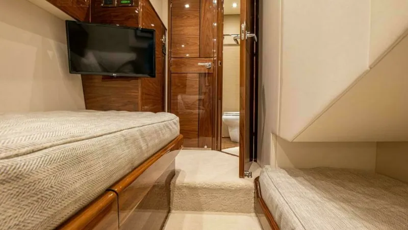 Slide: The Image of Guest Stateroom with Ensuite Access This cozy guest stateroom features twin berths with plush bedding and elegant wood finishes. A wall-mounted TV provides entertainment, while the en-suite bathroom is easily accessible, enhancing privacy and convenience. The soft lighting and neutral tones - 7600531