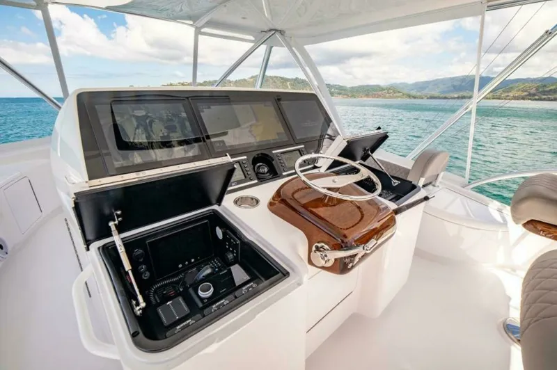 Slide: The Image of Flybridge Helm Station The flybridge helm station of the 2023 Viking 64 Convertible 'Twin Reels' showcases state-of-the-art navigation technology with dual displays and intuitive controls. The polished wooden accents and ergonomic seating enhance comfort and style, while the pa - 7530862