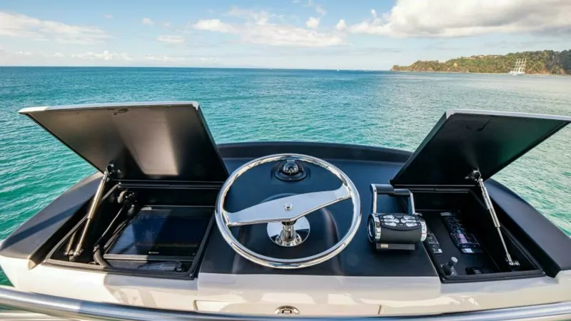 Slide: The Image of Flybridge Helm Station The flybridge helm station of the 2023 Viking 64 Convertible 'Twin Reels' offers a commanding view of the open sea. Featuring a sleek, modern design, the helm is equipped with state-of-the-art navigation controls and twin multifunction displays housed wit - 7600550