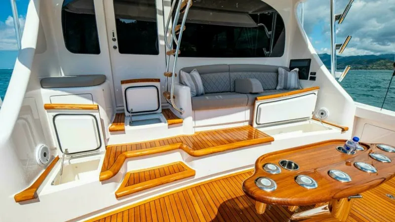Slide: The Image of Spacious Aft Deck with Seating The aft deck of the 2023 Viking 64 Convertible offers a perfect blend of functionality and luxury. Featuring polished teak flooring and a built-in cushioned seating area, it provides an inviting space for relaxation and socializing. The practical layout i - 7600555