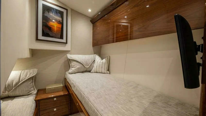 Slide: The Image of Cozy Twin Cabin with Wood Accents This inviting twin cabin on the 2023 Viking 64 Convertible 'Twin Reels' features elegant wood finishes and ambient recessed lighting. The comfortable twin beds are complemented by soft, neutral-toned linens and a sleek, mounted television for entertainmen - 7600530