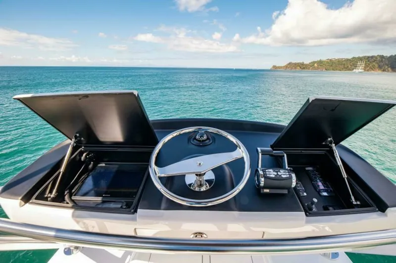 Slide: The Image of Flybridge Helm Station The flybridge helm station of the 2023 Viking 64 Convertible 'Twin Reels' offers a commanding view of the open sea. Featuring a sleek, modern design, the helm is equipped with state-of-the-art navigation controls and twin multifunction displays housed wit - 7530868