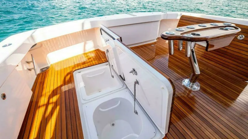 Slide: The Image of Teak Cockpit with Fishing Amenities This spacious cockpit on the 2023 Viking 64 Convertible features a beautifully finished teak deck, ideal for both relaxation and fishing activities. Equipped with a sturdy fishing station complete with rod holders and a built-in livewell, it offers conven - 7600557