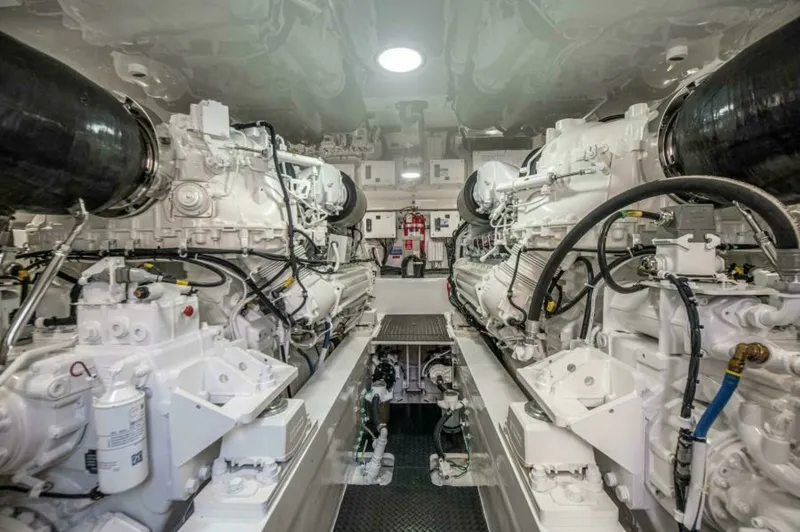 Slide: The Image of Engine Room with Twin Engines The engine room of the 2023 Viking 64 Convertible showcases its powerful twin engines, meticulously designed for optimal performance and efficiency. The space is well-organized, with a clean, bright finish that enhances visibility and accessibility. Moder - 7530878