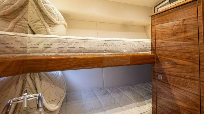 Slide: The Image of Cozy Twin Bunk Cabin The cabin features a well-designed twin bunk setup, providing comfortable sleeping arrangements with plush bedding. The warm wood finishes and soft lighting create an inviting atmosphere, ideal for restful nights at sea. Ample storage is subtly integrated - 7600533