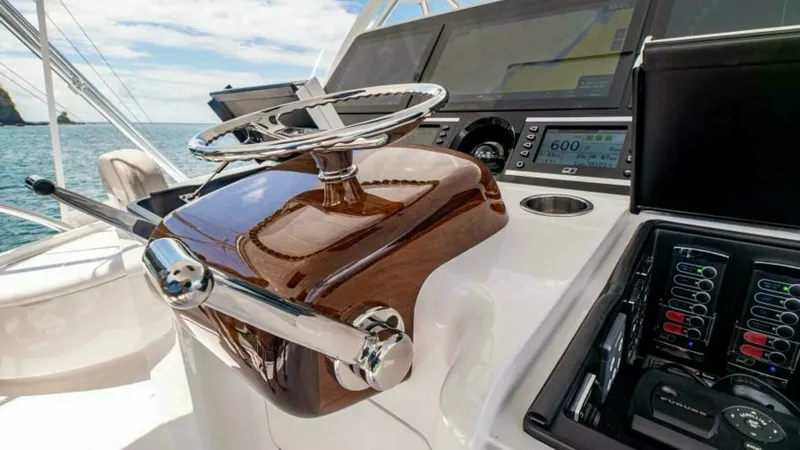 Slide: The Image of Flybridge Helm Station The helm station on the Viking 64 Convertible showcases state-of-the-art navigation technology with a sleek, polished wood steering console. The expansive display screens and controls are strategically positioned for easy access, enhancing the captain's c - 7600545
