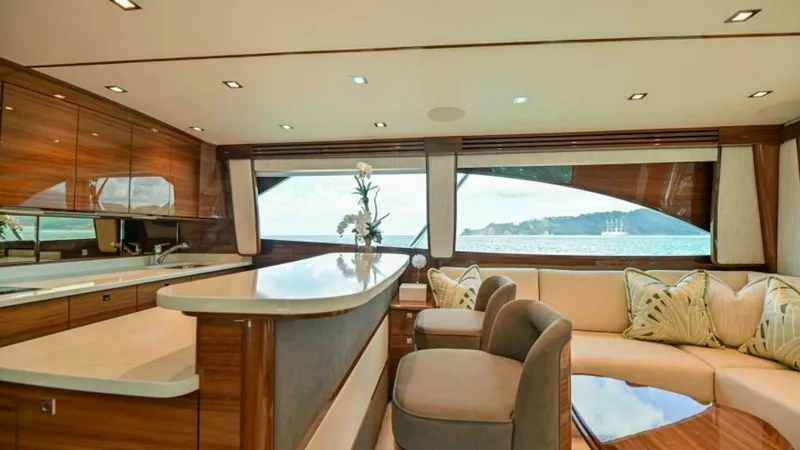 Slide: The Image of Elegant Interior Salon with Bar This luxurious salon aboard the 2023 Viking 64 Convertible features a sophisticated bar area with sleek countertops and high-end finishes. The plush seating arrangement offers comfort and style, complemented by large windows that provide stunning panorami - 7600513