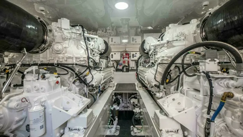 Slide: The Image of Engine Room with Twin Engines The engine room of the 2023 Viking 64 Convertible showcases its powerful twin engines, meticulously designed for optimal performance and efficiency. The space is well-organized, with a clean, bright finish that enhances visibility and accessibility. Moder - 7600560