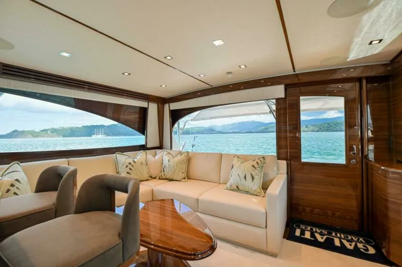 Slide: The Image of Spacious Salon with Scenic Views The salon of the 2023 Viking 64 Convertible offers a luxurious and inviting space with panoramic windows showcasing breathtaking ocean views. Featuring plush seating, elegant wood finishes, and abundant natural light, this area is perfect for relaxation a - 7530830