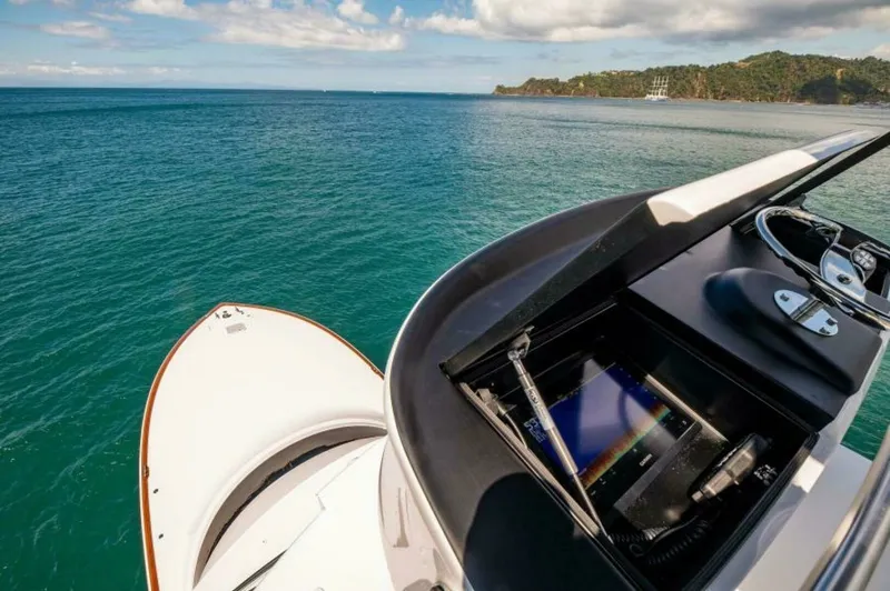 Slide: The Image of Flybridge Helm Station with Electronics The flybridge helm station on the 2023 Viking 64 Convertible 'Twin Reels' showcases a state-of-the-art navigation system. The helm offers a sleek design with an integrated display, stainless steel steering wheel, and ergonomic controls for seamless operat - 7530871