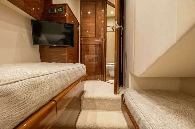 Slide: The Image of Guest Stateroom with Ensuite Access This cozy guest stateroom features twin berths with plush bedding and elegant wood finishes. A wall-mounted TV provides entertainment, while the en-suite bathroom is easily accessible, enhancing privacy and convenience. The soft lighting and neutral tones - 7530849