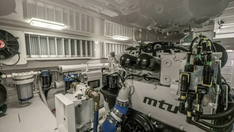Slide: The Image of Engine Room with MTU Engines This image showcases the state-of-the-art engine room of the 2023 Viking 64 Convertible, featuring powerful MTU engines. The space is meticulously organized, with high-quality components and advanced engineering for optimal performance. Bright lighting an - 7600562