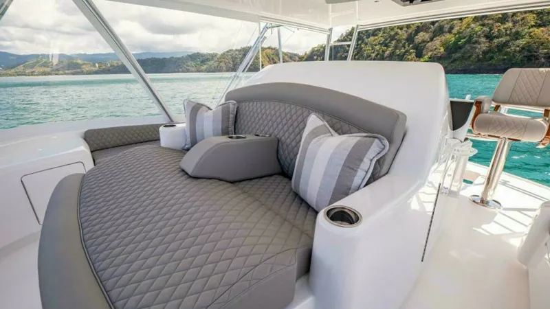 Slide: The Image of Flybridge Lounge Seating Area This luxurious flybridge lounge on the 2023 Viking 64 Convertible offers plush, diamond-stitched upholstery, providing comfort and style. The seating area features elegant accent pillows and integrated cup holders, ensuring a relaxing experience while tak - 7600548