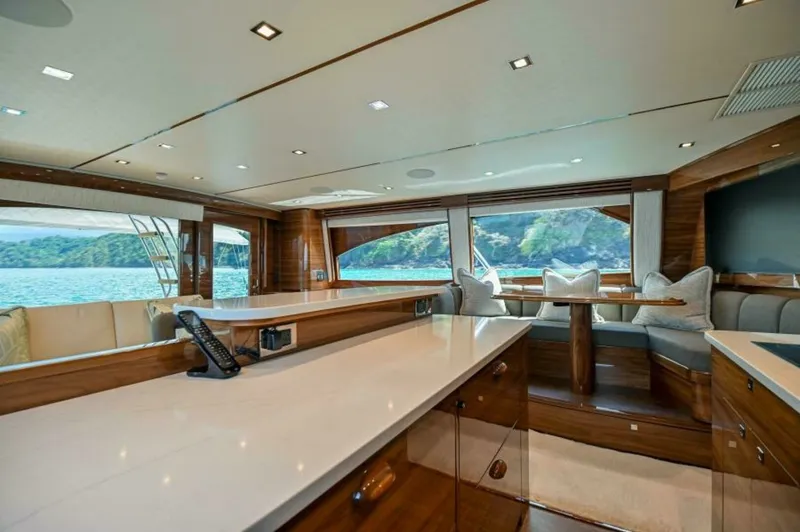 Slide: The Image of Spacious Salon with Panoramic Views This elegant salon on the 2023 Viking 64 Convertible 'Twin Reels' features expansive windows offering breathtaking panoramic views. The luxurious interior is adorned with high-quality wood finishes and plush seating, creating a welcoming and sophisticated - 7530837