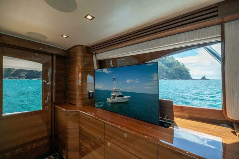 Slide: The Image of Luxurious Salon with Ocean View This elegant salon on the 2023 Viking 64 Convertible features rich wood finishes and a large flat-screen TV, providing a perfect blend of comfort and entertainment. Expansive windows offer breathtaking views of the ocean, enhancing the sense of space and - 7530840