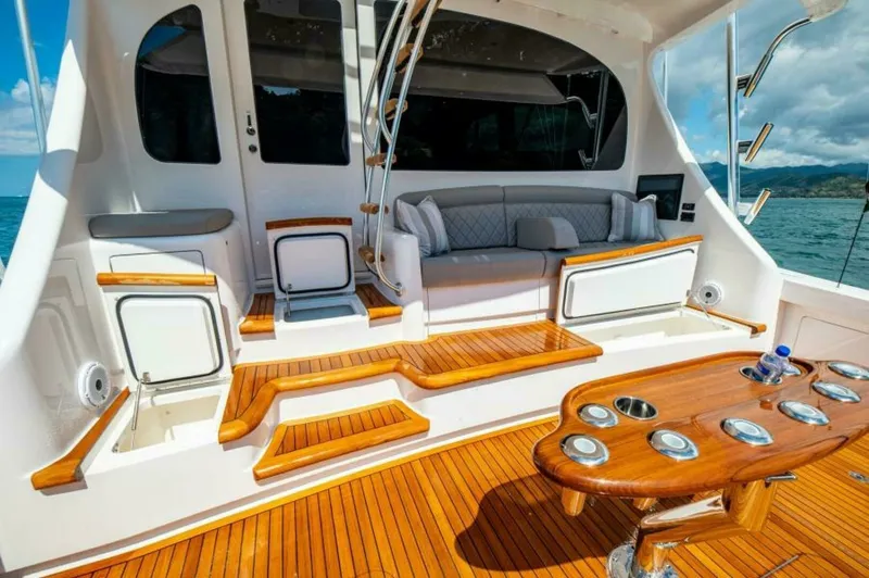 Slide: The Image of Spacious Aft Deck with Seating The aft deck of the 2023 Viking 64 Convertible offers a perfect blend of functionality and luxury. Featuring polished teak flooring and a built-in cushioned seating area, it provides an inviting space for relaxation and socializing. The practical layout i - 7530873