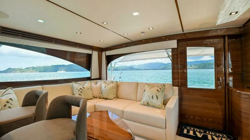 Slide: The Image of Spacious Salon with Scenic Views The salon of the 2023 Viking 64 Convertible offers a luxurious and inviting space with panoramic windows showcasing breathtaking ocean views. Featuring plush seating, elegant wood finishes, and abundant natural light, this area is perfect for relaxation a - 7600512