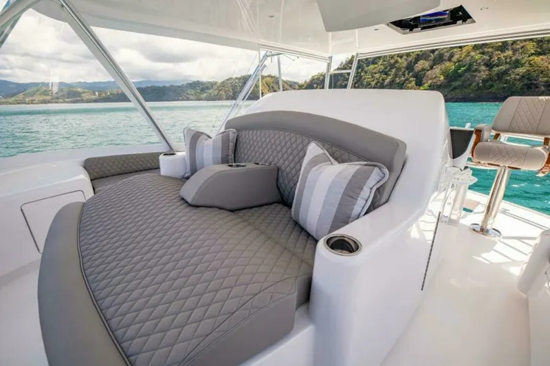 Slide: The Image of Flybridge Lounge Seating Area This luxurious flybridge lounge on the 2023 Viking 64 Convertible offers plush, diamond-stitched upholstery, providing comfort and style. The seating area features elegant accent pillows and integrated cup holders, ensuring a relaxing experience while tak - 7530866