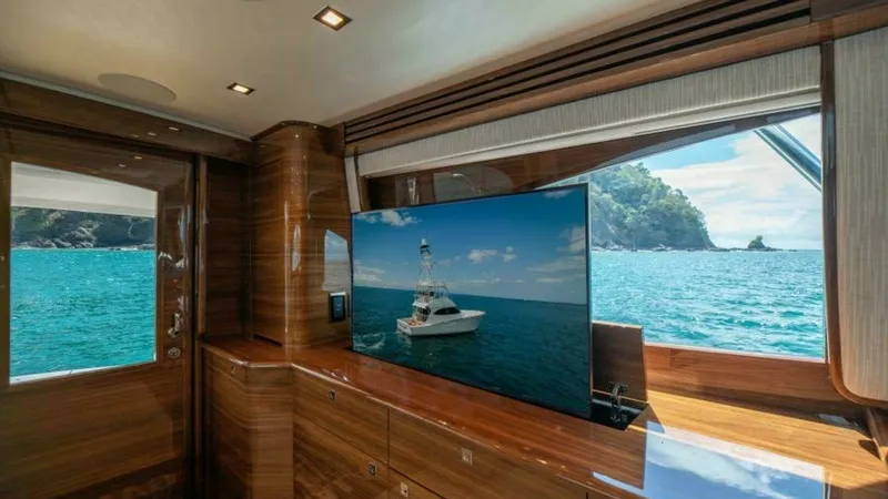 Slide: The Image of Luxurious Salon with Ocean View This elegant salon on the 2023 Viking 64 Convertible features rich wood finishes and a large flat-screen TV, providing a perfect blend of comfort and entertainment. Expansive windows offer breathtaking views of the ocean, enhancing the sense of space and - 7600522