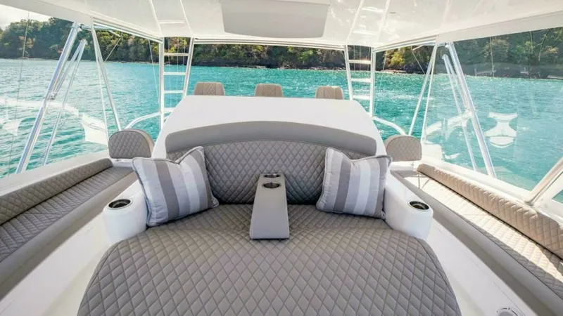 Slide: The Image of Flybridge Lounge Seating Area The flybridge of the 2023 Viking 64 Convertible features a luxurious lounge seating area with plush, quilted cushions and tasteful accent pillows. The spacious layout provides ample room for relaxation, while the panoramic views through the surrounding cl - 7600509