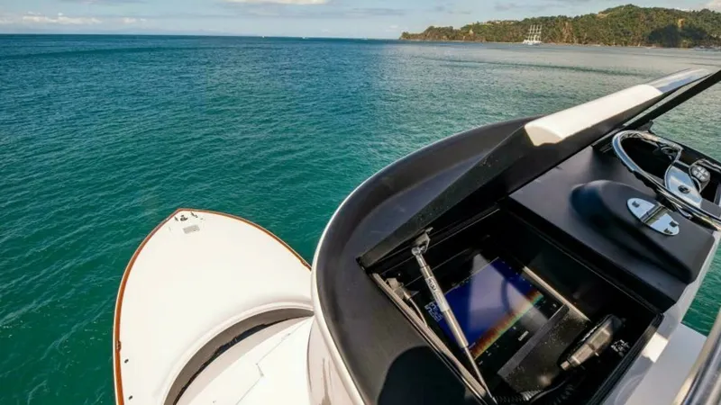 Slide: The Image of Flybridge Helm Station with Electronics The flybridge helm station on the 2023 Viking 64 Convertible 'Twin Reels' showcases a state-of-the-art navigation system. The helm offers a sleek design with an integrated display, stainless steel steering wheel, and ergonomic controls for seamless operat - 7600553