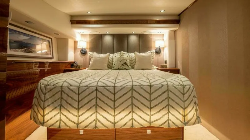 Slide: The Image of Luxurious Master Stateroom The master stateroom of the 2023 Viking 64 Convertible exudes elegance with its plush bedding and ambient lighting. Rich wood finishes and modern wall sconces enhance the luxurious atmosphere, while the spacious layout provides comfort and style. This inv - 7600508
