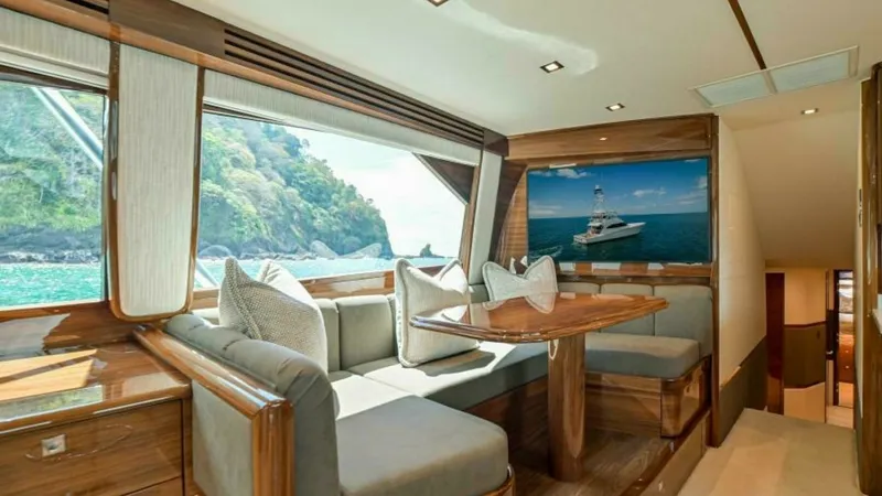 Slide: The Image of Elegant Interior Dining Nook The dining nook of the 2023 Viking 64 Convertible features luxurious upholstery and polished wood finishes, offering a comfortable space for meals or relaxation. Large windows provide breathtaking views of the surrounding seascape, enhancing the ambiance - 7600520