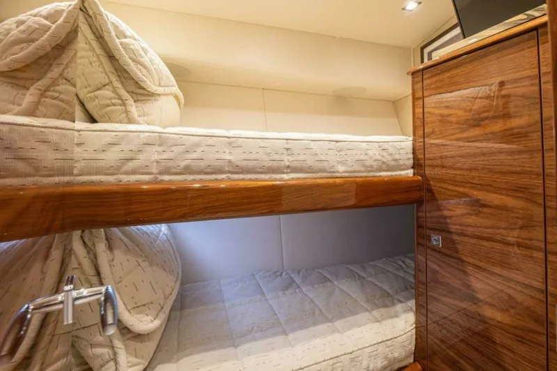 Slide: The Image of Cozy Twin Bunk Cabin The cabin features a well-designed twin bunk setup, providing comfortable sleeping arrangements with plush bedding. The warm wood finishes and soft lighting create an inviting atmosphere, ideal for restful nights at sea. Ample storage is subtly integrated - 7530851