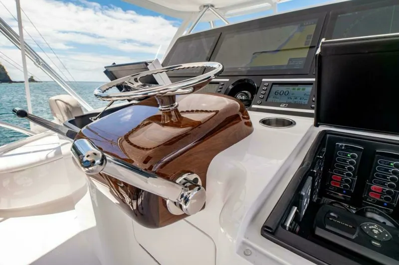 Slide: The Image of Flybridge Helm Station The helm station on the Viking 64 Convertible showcases state-of-the-art navigation technology with a sleek, polished wood steering console. The expansive display screens and controls are strategically positioned for easy access, enhancing the captain's c - 7530863