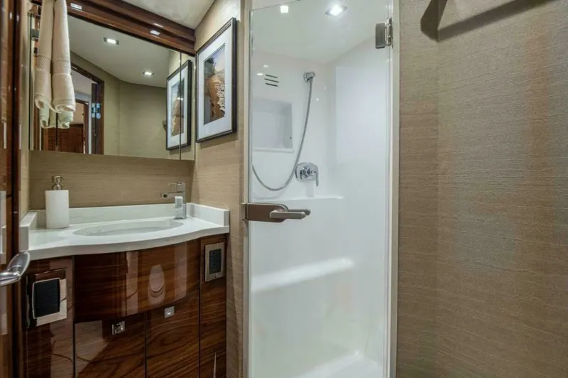 Slide: The Image of Luxurious Ensuite Bathroom This elegant ensuite bathroom features high-gloss wood cabinetry and modern fixtures, providing a touch of luxury on the Viking 64 Convertible. The spacious shower enclosure is complemented by sleek, recessed lighting, creating a bright and inviting atmos - 7530853
