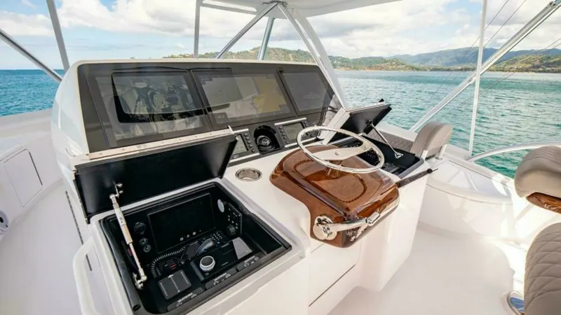 Slide: The Image of Flybridge Helm Station The flybridge helm station of the 2023 Viking 64 Convertible 'Twin Reels' showcases state-of-the-art navigation technology with dual displays and intuitive controls. The polished wooden accents and ergonomic seating enhance comfort and style, while the pa - 7600544