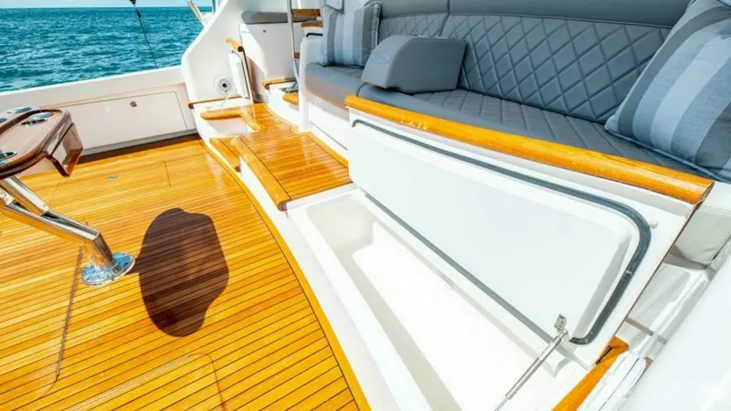 Slide: The Image of Cockpit Seating with Storage Access The cockpit of the 2023 Viking 64 Convertible offers luxurious seating with diamond-stitched upholstery, providing comfort and style. Beneath the seating, a convenient storage compartment is accessible, perfect for stowing gear and essentials. The teak fl - 7600558