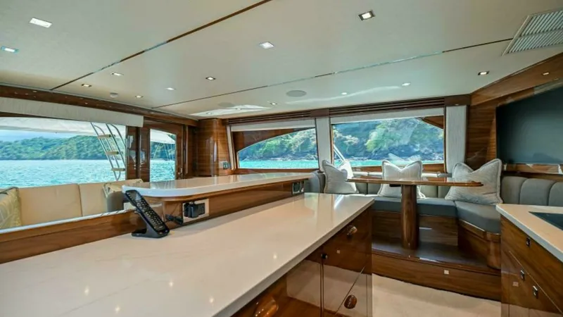 Slide: The Image of Spacious Salon with Panoramic Views This elegant salon on the 2023 Viking 64 Convertible 'Twin Reels' features expansive windows offering breathtaking panoramic views. The luxurious interior is adorned with high-quality wood finishes and plush seating, creating a welcoming and sophisticated - 7600519
