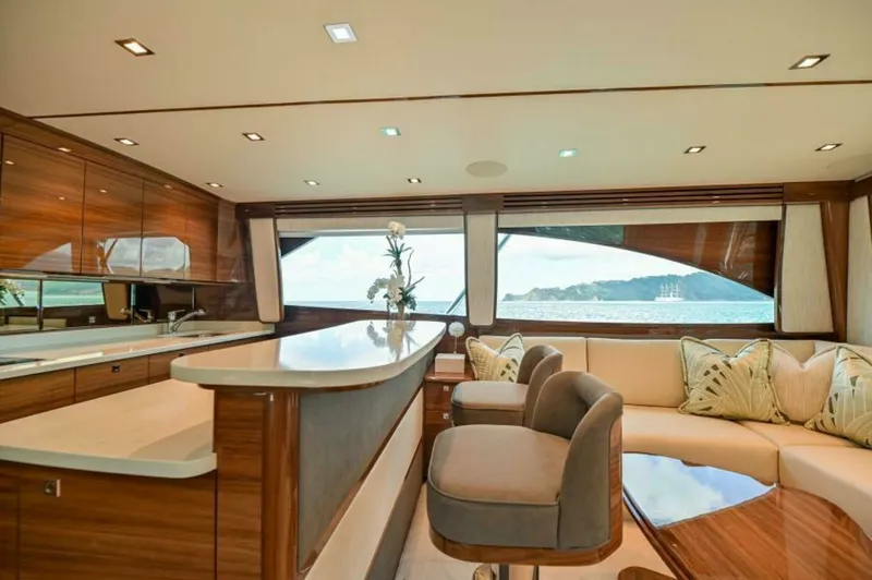 Slide: The Image of Elegant Interior Salon with Bar This luxurious salon aboard the 2023 Viking 64 Convertible features a sophisticated bar area with sleek countertops and high-end finishes. The plush seating arrangement offers comfort and style, complemented by large windows that provide stunning panorami - 7530831