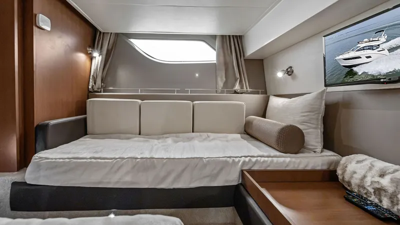 Slide: The Image of Cozy Guest Stateroom Interior This inviting guest stateroom on the 2018 Sea Ray 400 Fly, Tee Time III, features a comfortable single berth with plush bedding. The room is enhanced by a large window, allowing natural light to create a warm ambiance. A flat-screen TV and elegant wood fi - 7762708