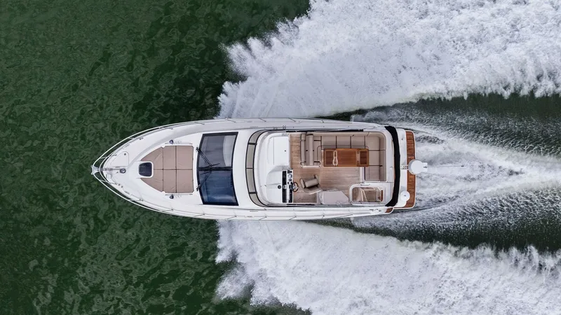 Slide: The Image of Aerial View of Flybridge and Deck This stunning aerial shot captures the Sea Ray 400 Fly's spacious flybridge and deck layout. The seating area is elegantly arranged with plush cushions, providing ample space for relaxation and entertainment. The vessel's sleek design and powerful perform - 7762739