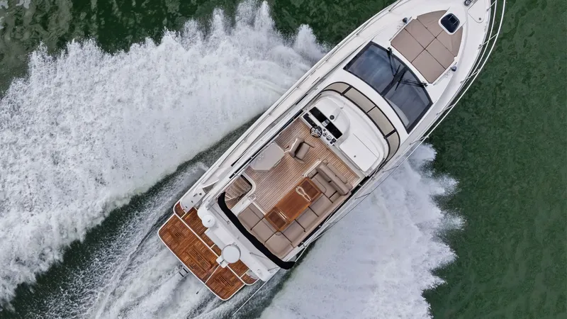 Slide: The Image of Aerial View of Flybridge and Deck This aerial shot showcases the expansive flybridge and deck of the 2018 Sea Ray 400 Fly, Tee Time III. The image highlights the luxurious seating area with plush cushions, perfect for entertaining or relaxing. The sleek, modern design is complemented by t - 7762740
