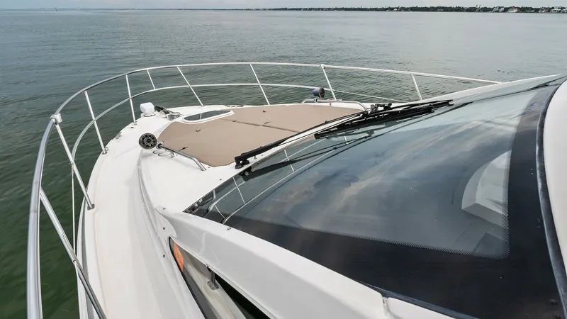 Slide: The Image of Bow and Forward Deck View This image showcases the sleek bow of the 2018 Sea Ray 400 Fly, Tee Time III. The forward deck features a spacious sun pad, perfect for lounging and enjoying panoramic ocean views. The streamlined design and stainless steel railings enhance both safety an - 7762746