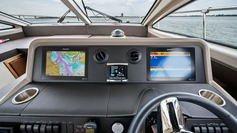 Slide: The Image of Modern Helm with Dual Displays The helm of the 2018 Sea Ray 400 Fly features a sleek design with dual high-resolution displays, providing comprehensive navigation and system controls. The ergonomic steering wheel and intuitive layout ensure ease of operation, while the expansive windsh - 7762690