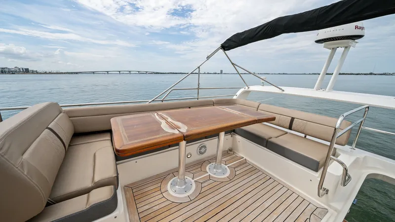 Slide: The Image of Flybridge Seating with Teak Table The flybridge of the 2018 Sea Ray 400 Fly features a spacious seating area with plush, wraparound cushions, perfect for socializing and enjoying panoramic views. A beautifully crafted teak table offers ample space for dining or entertaining. The area is c - 7762712