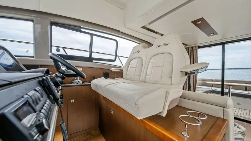 Slide: The Image of Helm Station with Dual Seating The helm station of the 2018 Sea Ray 400 Fly features plush dual seating, offering comfort and style for the captain and companion. The area is adorned with sleek wood finishes that complement the modern control panel, enhancing the vessel's sophisticated - 7762688